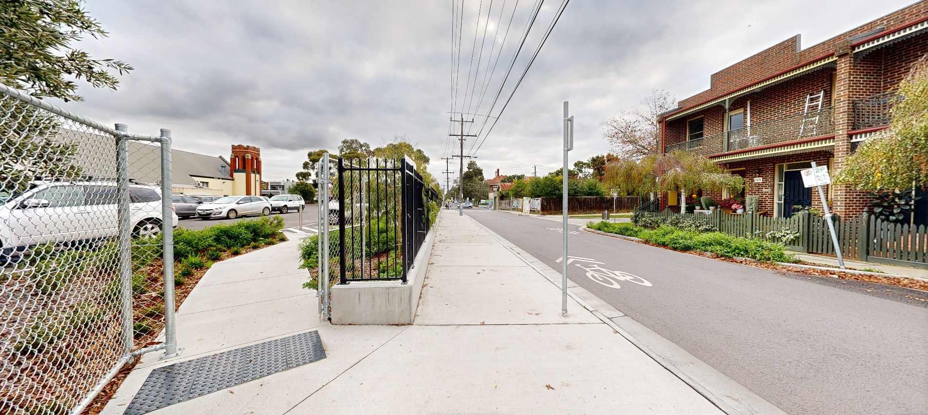 After: A view down Stewart Street after the upgrades. the footpath is wider and easier to see. There is a new path into the car park and new fence and shrubs along the street side of the carpark